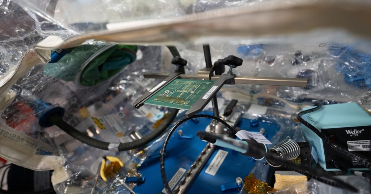 A circuit board is pictured inside a container system inside the International Space Station.